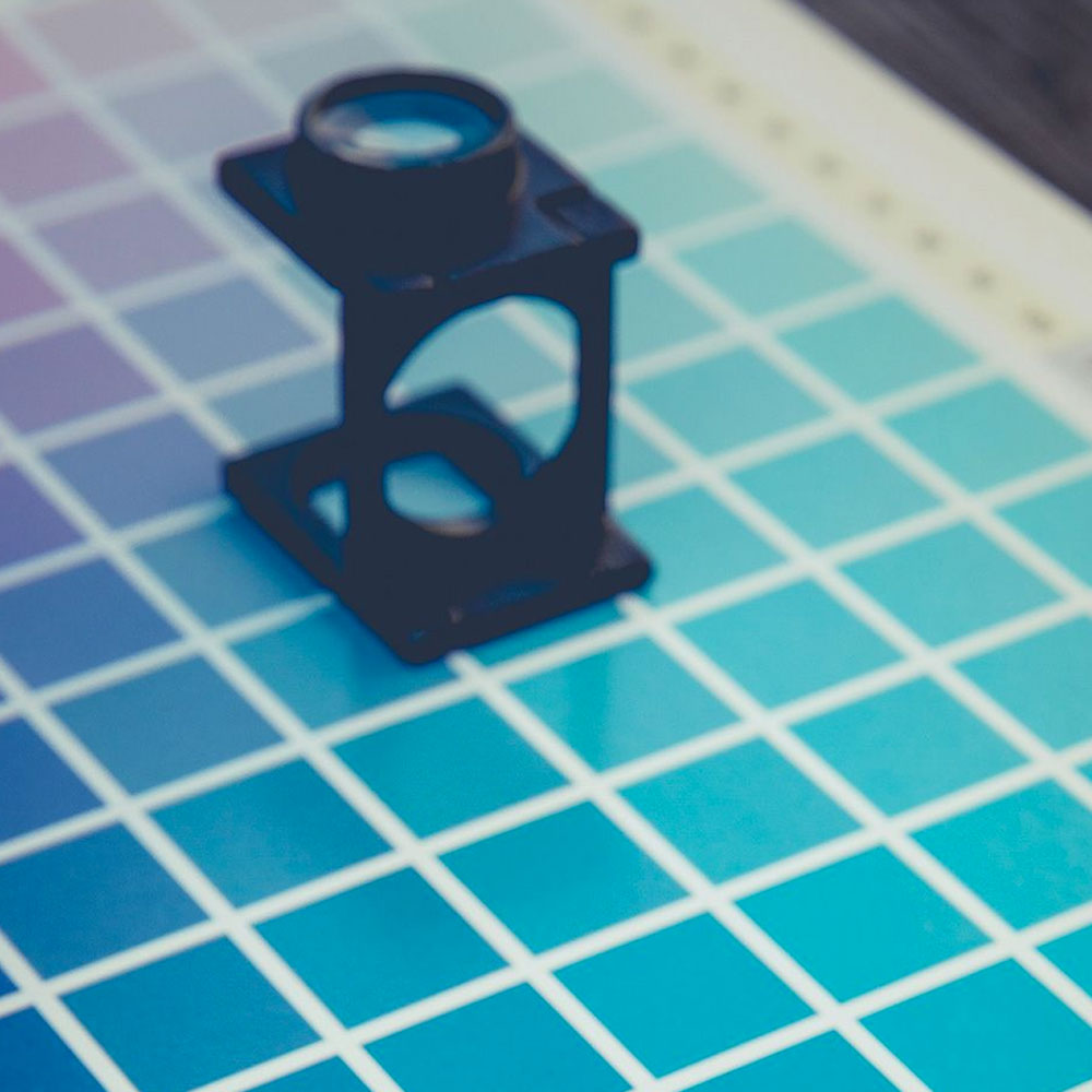 An eyepiece sits ontop of a graphic designer colour chart.